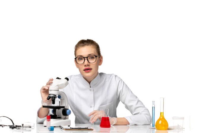 front-view-female-doctor-white-medical-suit-working-with-solutions-using-microscope-white-space